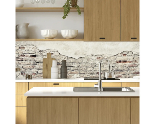 Scène de cuisine avec évier, robinet, vaisselle et décoration murale aspect maçonnerie