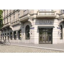 Vue extérieure d''un café dans un bâtiment classique avec des auvents et des vélos devant la porte