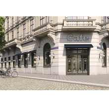Aussenansicht eines Cafés in einem Eckgebäude mit Markisen und Fahrrädern