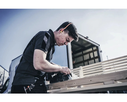 Artisan rabotant du bois avec un rabot électrique à l''extérieur