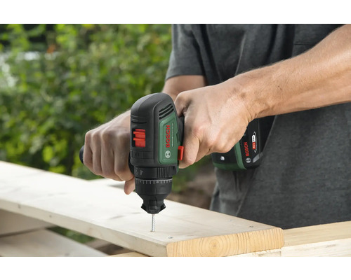 Mann schraubt Schraube mit einem Bosch Akku-Bohrschrauber in ein Holzbrett