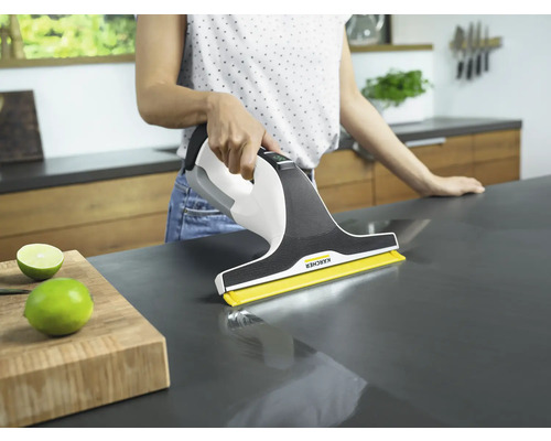 Femme nettoie un plan de travail avec un aspirateur de vitres Kärcher