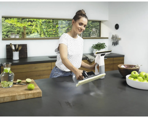 Femme nettoie une table de cuisine avec un aspirateur de vitres