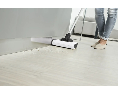 Personne qui aspire le sol avec un aspirateur