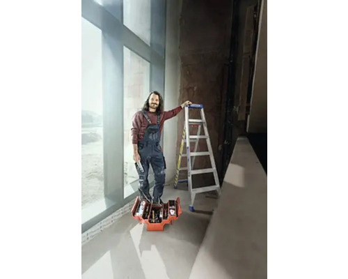 Artisan avec une boîte à outils et une échelle dans une pièce lumineuse.