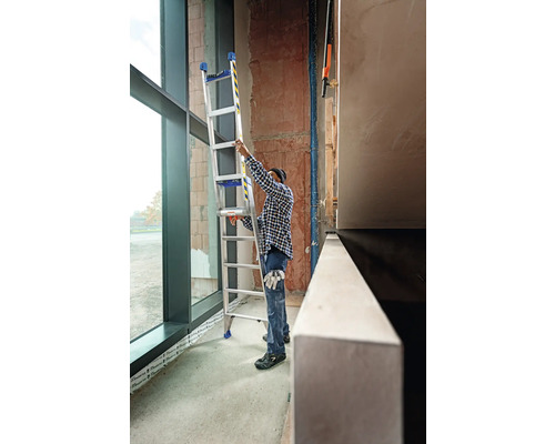 Un artisan place une échelle multifonctionnelle dans un bâtiment.