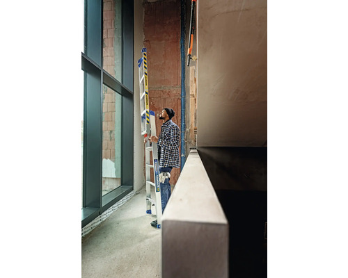 Homme avec échelle multifonctionnelle en aluminium dans un chantier