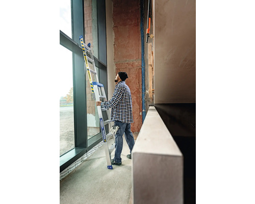 Une personne tient une échelle multifonctionnelle dans une pièce avec une grande fenêtre.