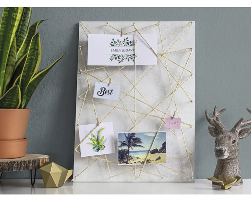 Dekoratives Memoboard mit Schnurdesign und Fotos auf einem Tisch