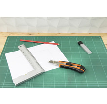 Tapis de découpe avec cutter, règle, crayon et papier