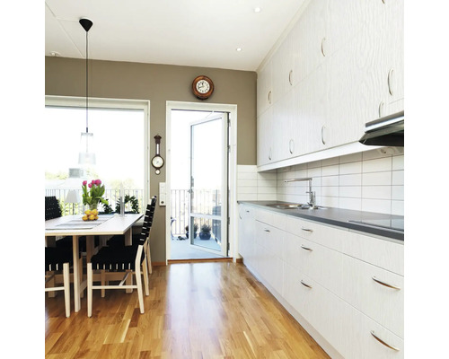 Cuisine claire avec coin repas, parquet et accès au balcon.