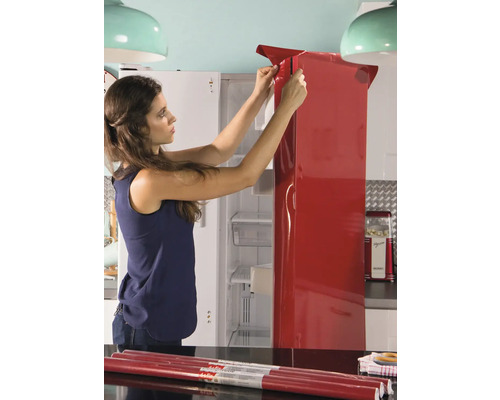 Frau bringt Folie auf Kühlschrank an