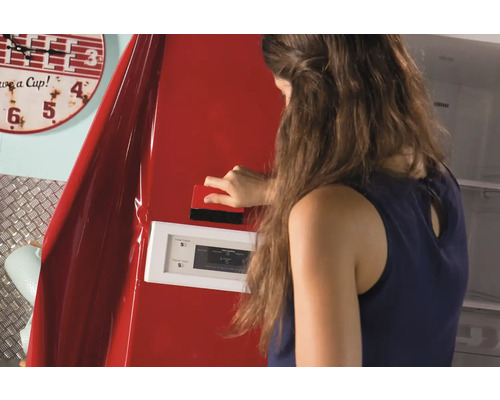 Frau bringt Dekorfolie mit einem Rakel auf einen Kühlschrank an