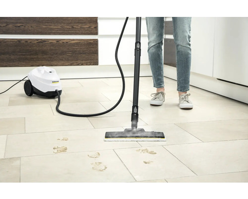 Nettoyeur à vapeur en cours d''utilisation sur un sol carrelé avec des traces de saleté, logo Kärcher visible