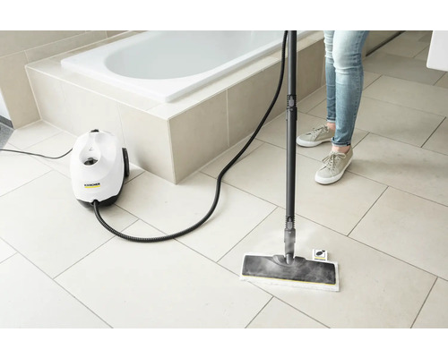 Nettoyeur vapeur en cours d''utilisation dans une salle de bains avec baignoire