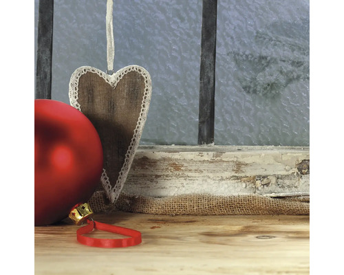 Pendentif décoratif en bois en forme de cœur avec boule de Noël rouge devant une fenêtre givrée
