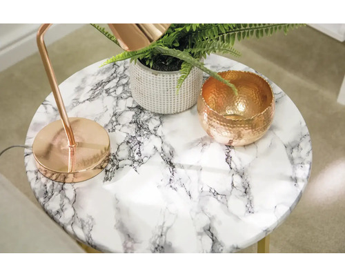 Table décorative avec aspect marbre et lampe, plante et bol cuivrés.