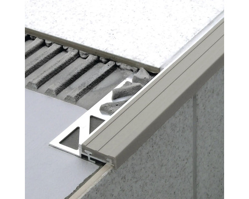 Detailaufnahme einer Fliesenabschlussschiene aus Metall an einer Wand