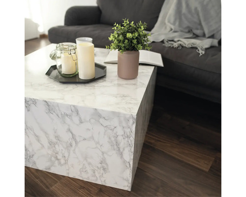 Salon avec table basse aspect marbre, bougies et décoration