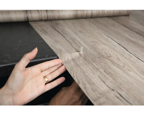 Film décoratif autocollant avec aspect bois en cours d''application