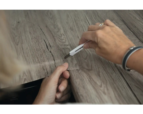 Découpe d''un sol en vinyle avec un cutter.