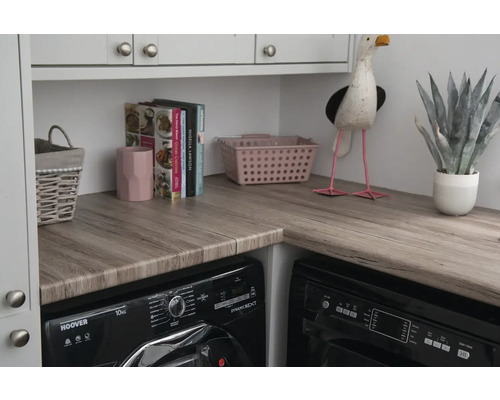 Scène de buanderie avec lave-linge, sèche-linge et éléments décoratifs sur un plan de travail