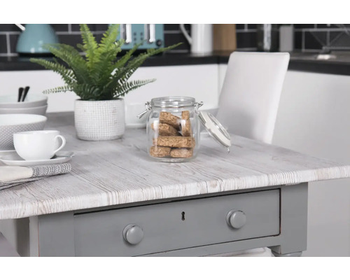 Arrangement décoratif avec table, vaisselle et pot de stockage dans une cuisine.