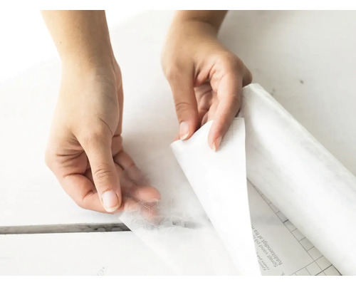 Les mains retirent le film protecteur d''un film décoratif autocollant