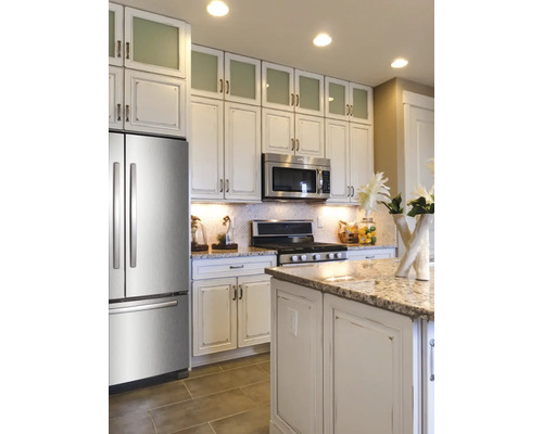 Cuisine lumineuse avec armoires encastrées, appareils en acier inoxydable et îlot de cuisine