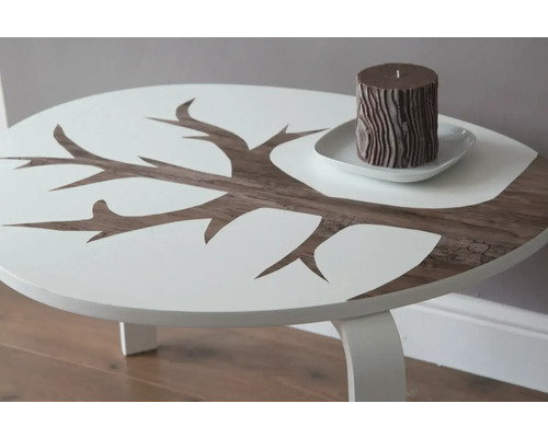 Tisch mit Baumdesign und Kerze auf Untertasse