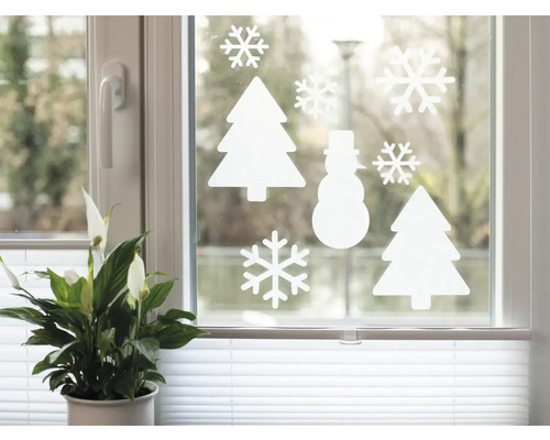 Dekoratives Fenster mit weißen Aufklebern in Form von Schneeflocken, Weihnachtsbäumen und einem Schneemann