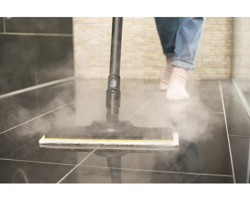 Nettoyeur vapeur en cours d''utilisation sur un sol carrelé dans une salle de bain