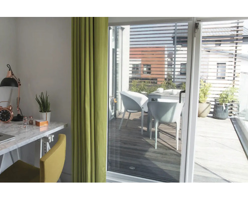 Pièce lumineuse avec bureau, chaise et rideau, vue sur une terrasse avec table et chaises