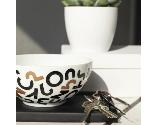Bol décoratif avec motif de lettres, plante en pot et clés sur une table
