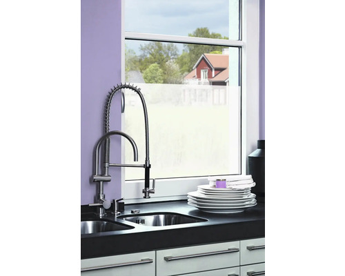 Évier de cuisine avec robinet devant une fenêtre