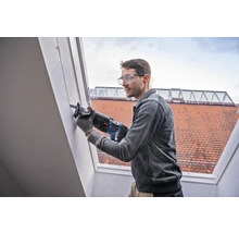 Un homme utilise une scie sabre sur un mur