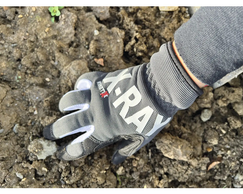 Une main avec un gant de travail touche la terre.