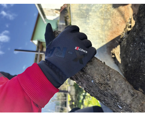 Une main gantée tenant une pierre.