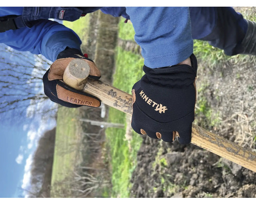 Hände mit Arbeitshandschuhen halten einen Hammer