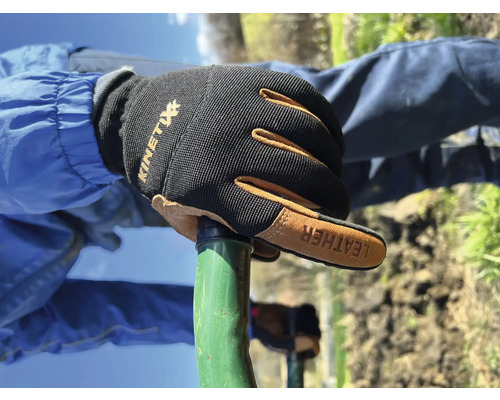 Hand mit Kinetix Arbeitshandschuhen an einem Gartengerät