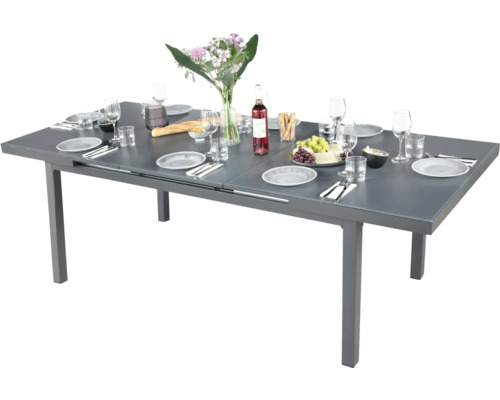 Gedeckter Gartentisch ausziehbar mit Geschirr und Dekoration.