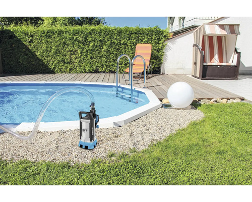 Pompe submersible au bord de la piscine avec mobilier de jardin en arrière-plan