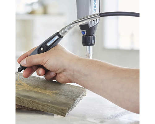 Outil multifonction Dremel avec arbre flexible utilisé sur une pièce de bois.