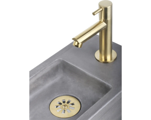 Aufnahme eines Waschbeckens mit goldfarbener Armatur und Abfluss