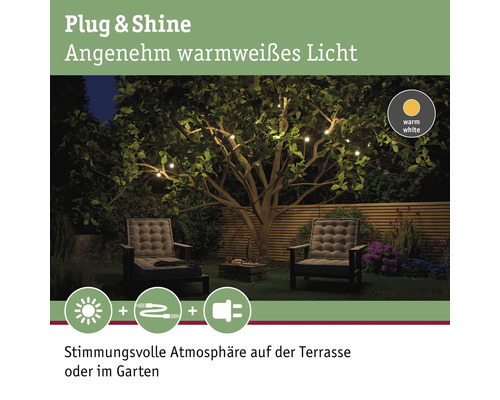 Gartenambiente mit warmweisser Lichterkette, Gartensesseln und Holzzaun