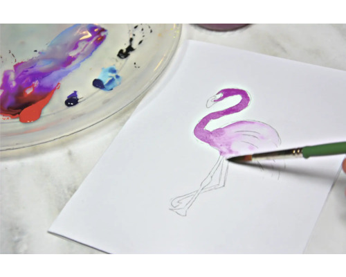 Peinture aquarelle d''un flamant rose sur papier avec pinceau et palette