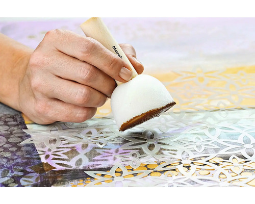 Main peignant une toile avec un tampon et un pochoir