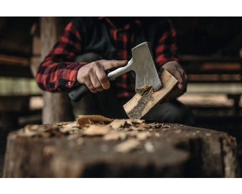 Homme fendant une bûche avec une hache à fendre sur un billot