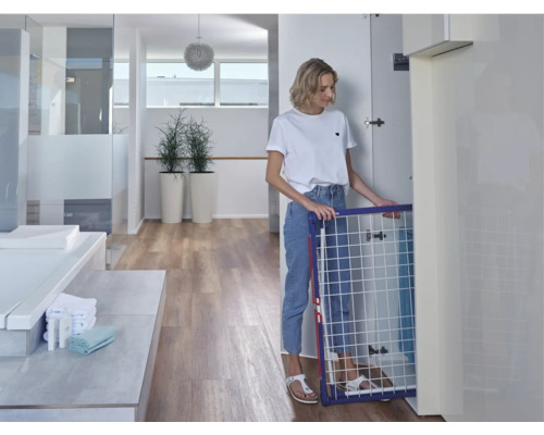 Femme pliant un séchoir à linge dans une salle de bain