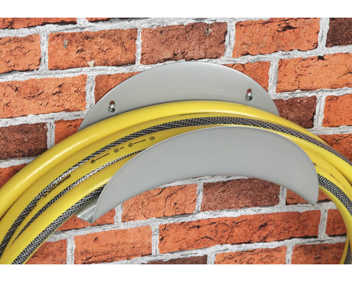 Tuyau d''arrosage sur support de tuyau sur un mur en briques